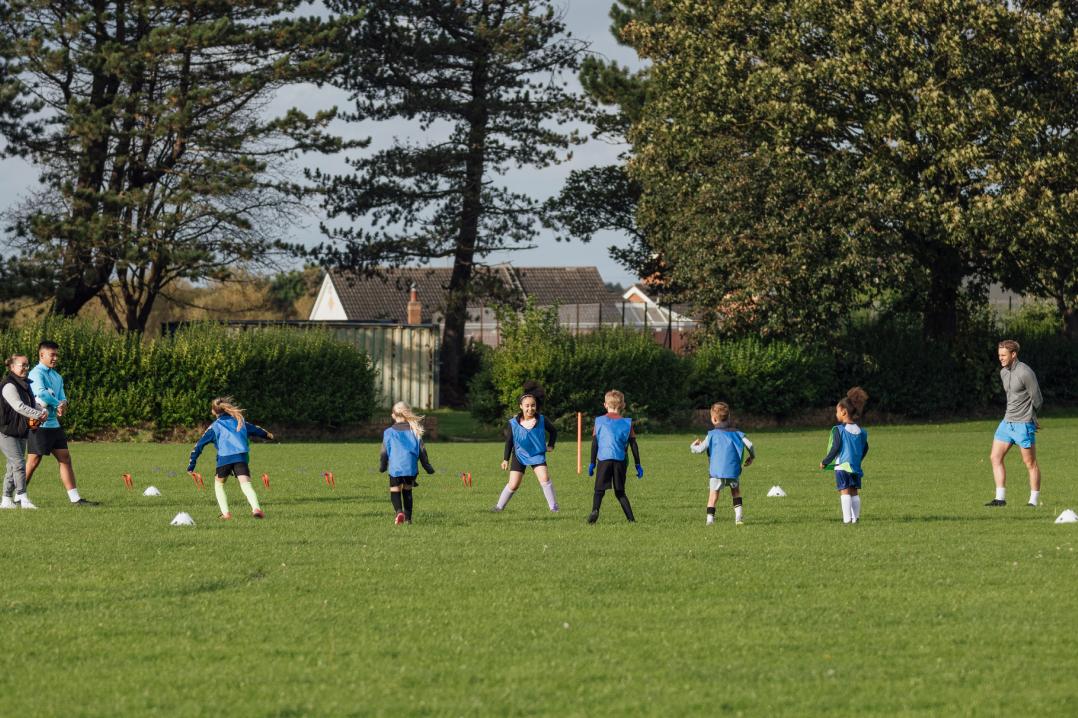 Kids playing football in a field