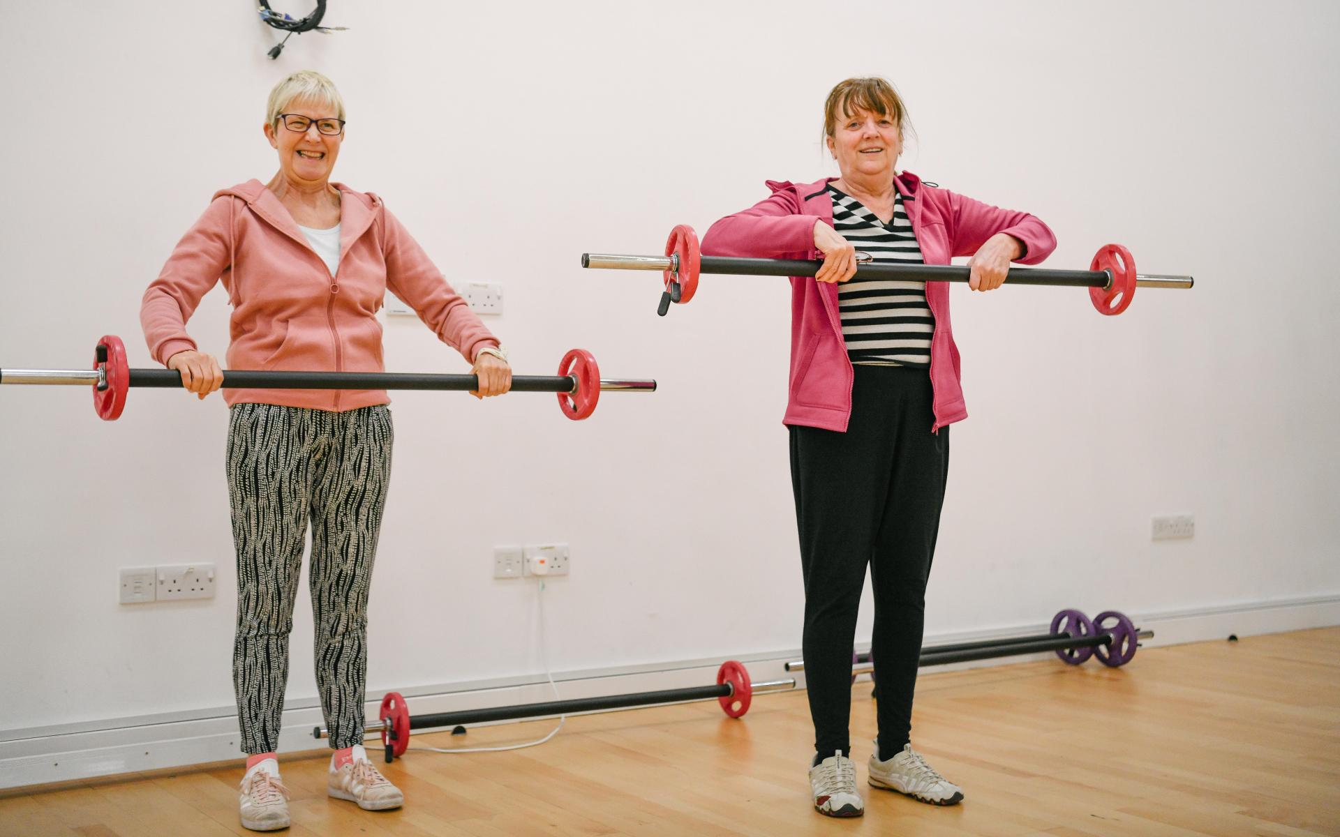 Two women holding weights.