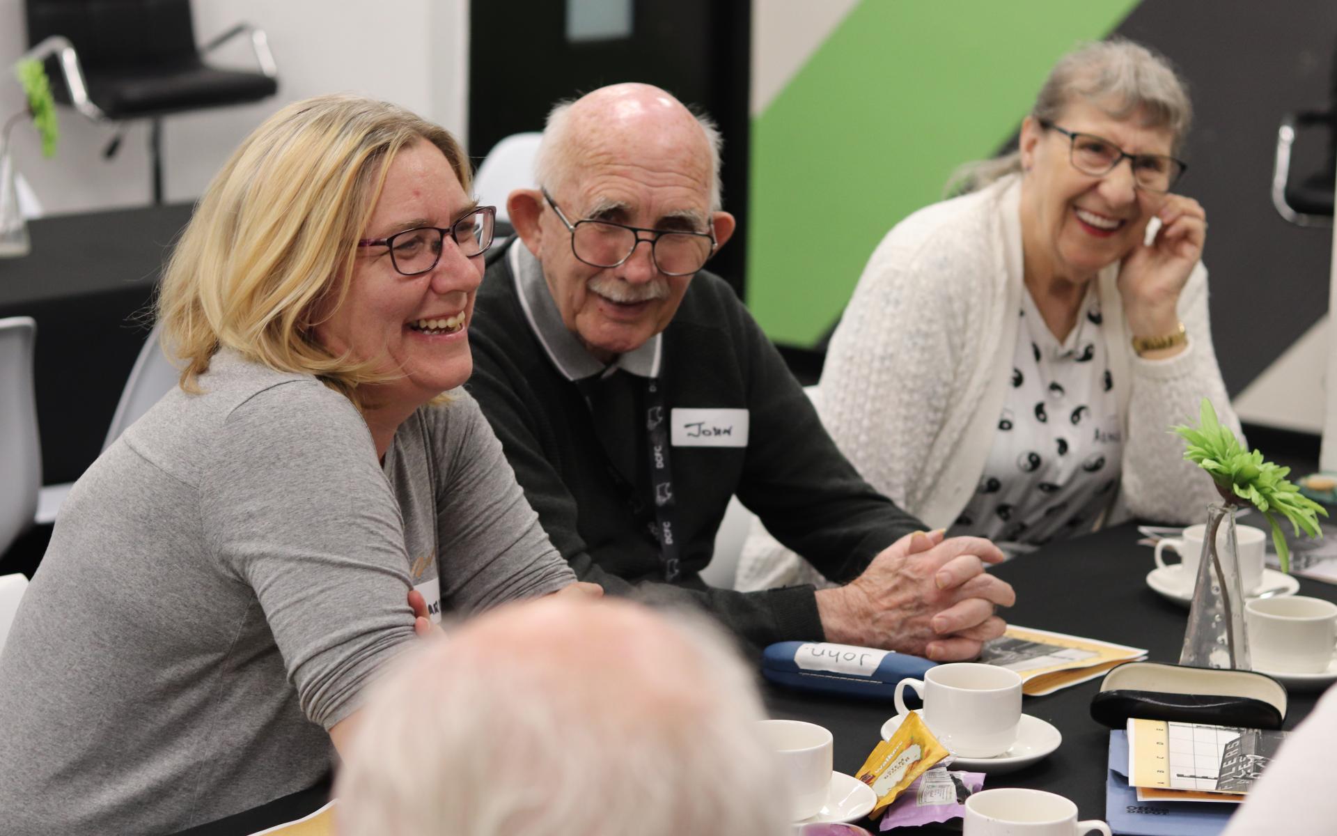 Group of people smiling sitting at a table
