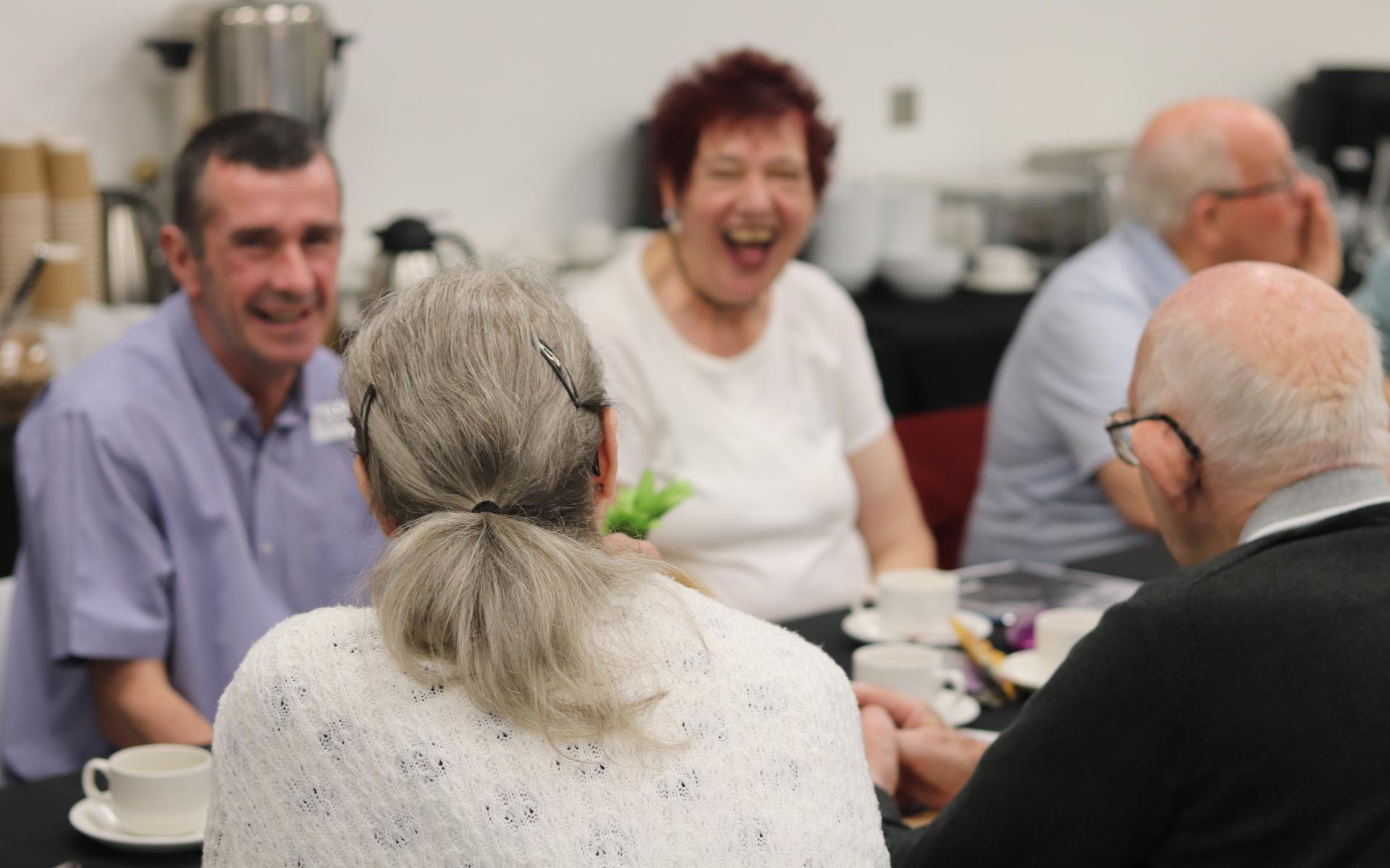 Group of people smiling sitting at a table