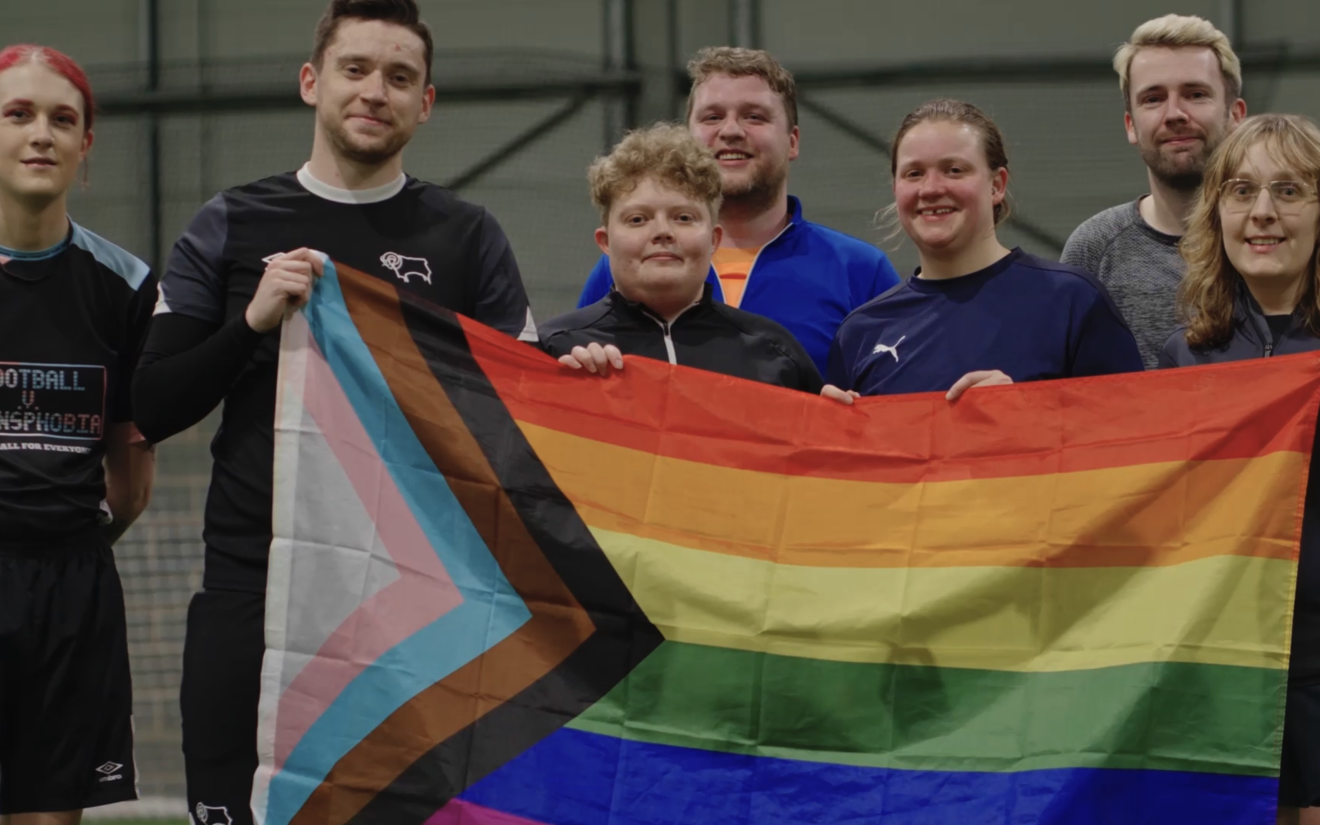 Participants and staff hold an LGBTQ+ flag after the Pride Park Pride session at Moor Farm.