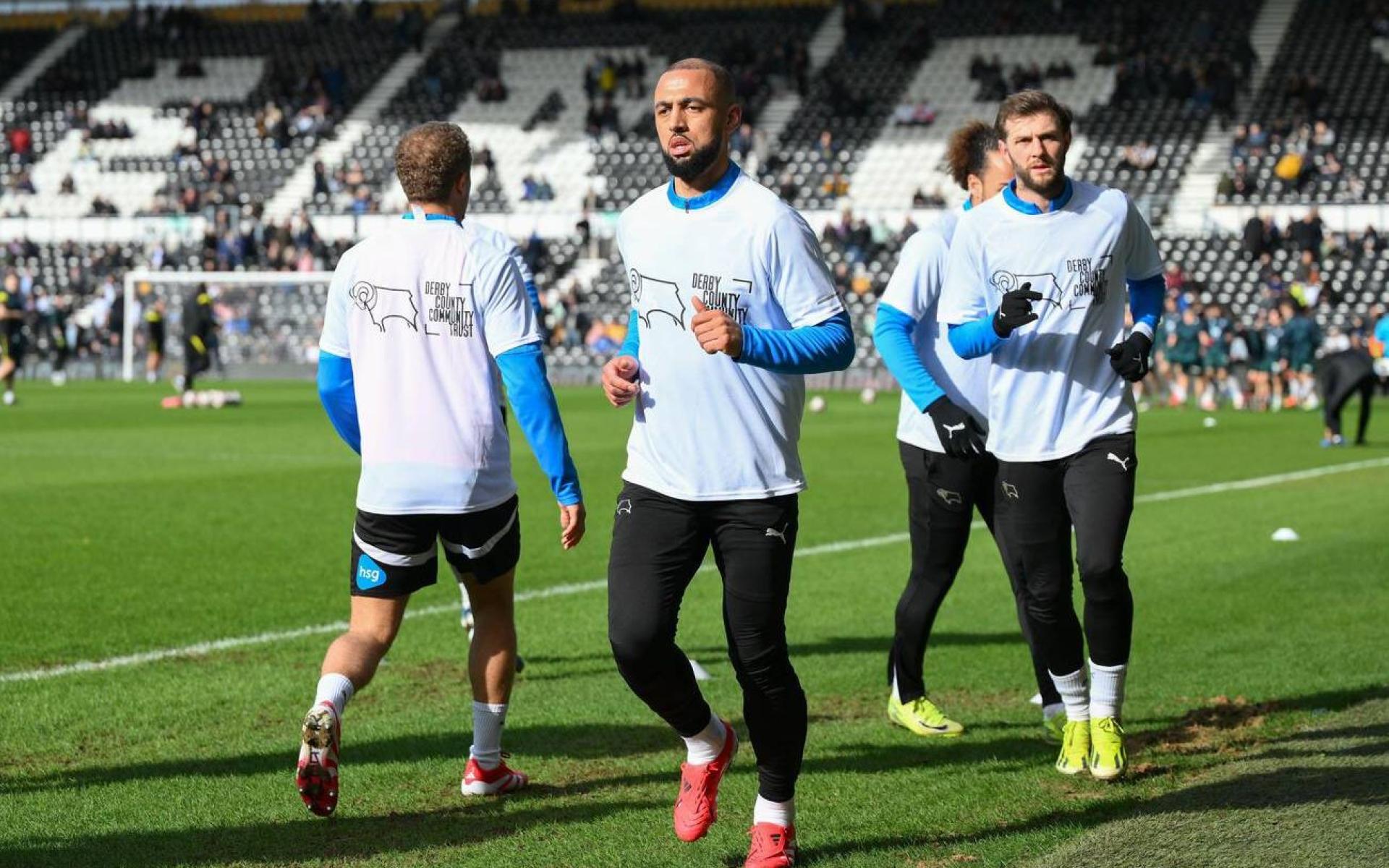 Derby County first team players at Pride Park warming up in DCCT branded warm up t-shirts