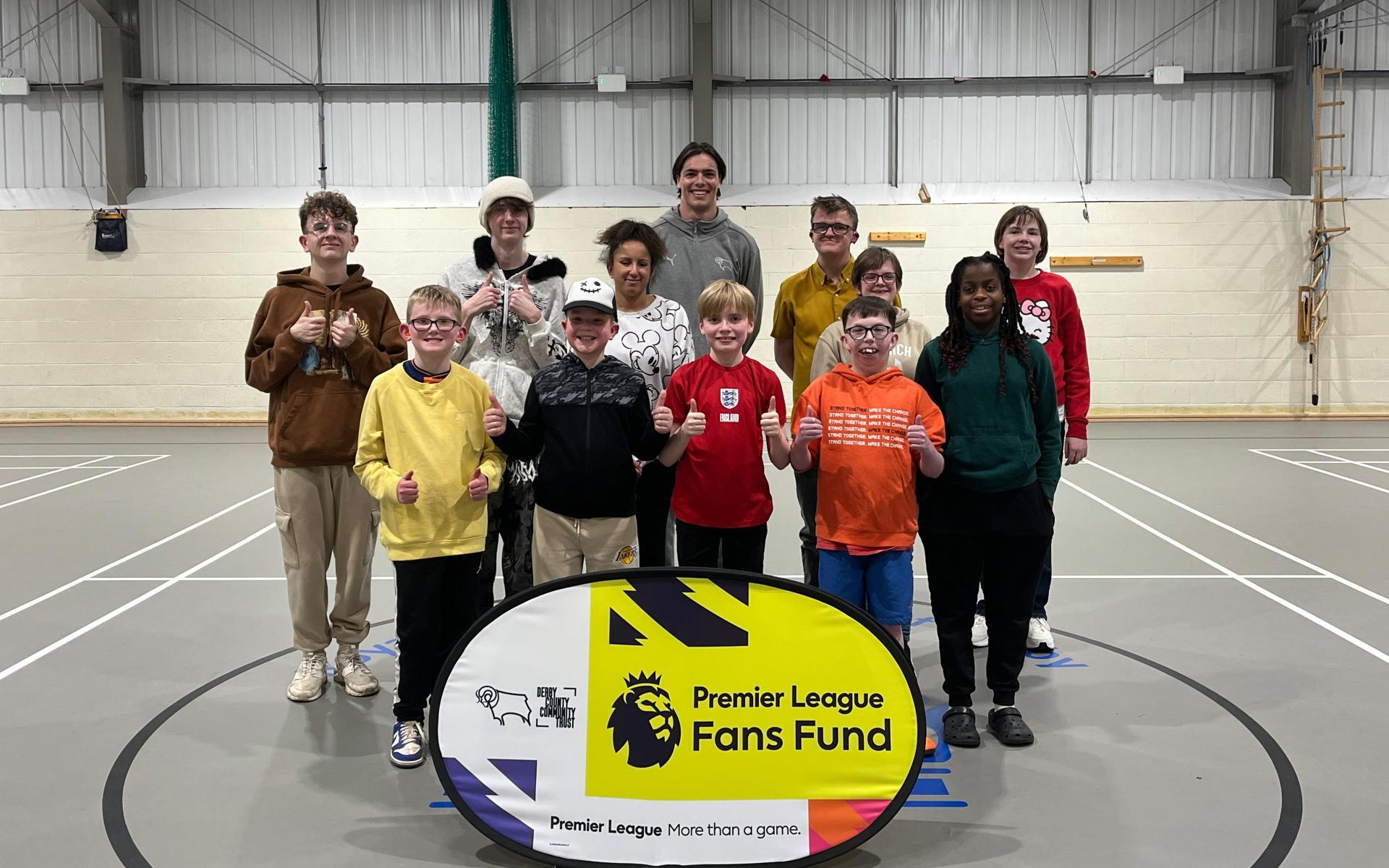 Jacob and the group in front of the Premier League Fans Fund sign
