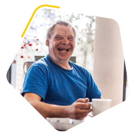 Male service user sat with a cup of tea