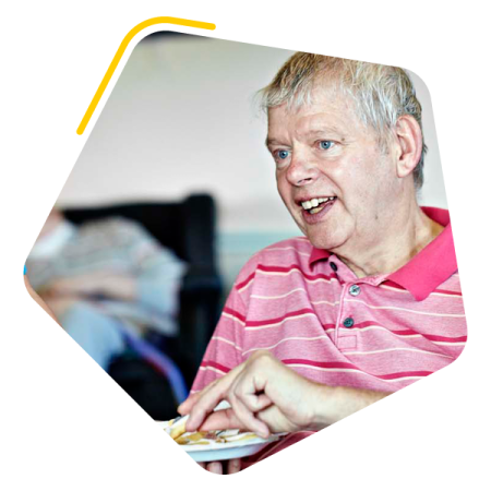 Male service user sat with a care worker in a care home