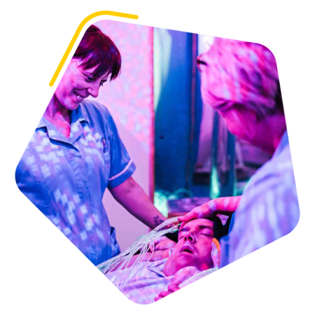 Male service user in a sensory room with two care workers