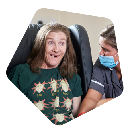 Female service user sat in chair with care worker