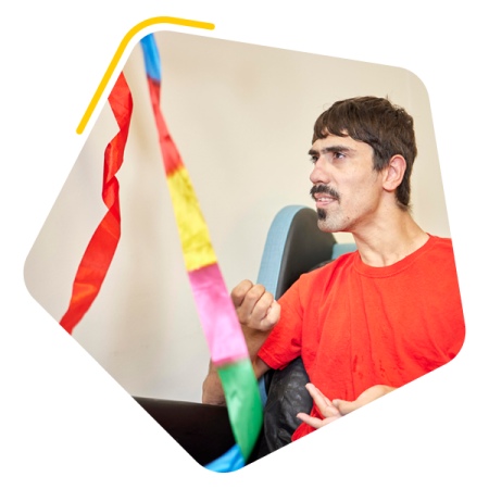 Man sat in a wheelchair with a ribbon