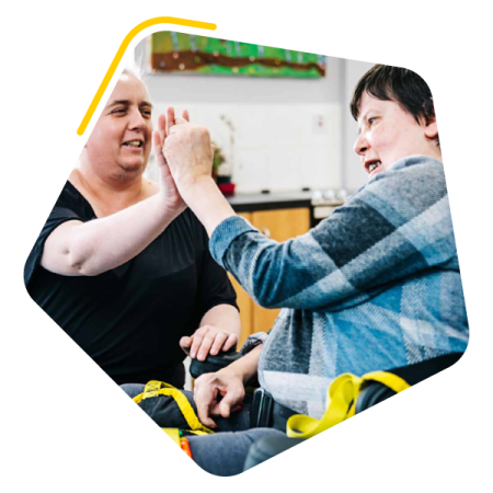Female service user holding hands with care worker