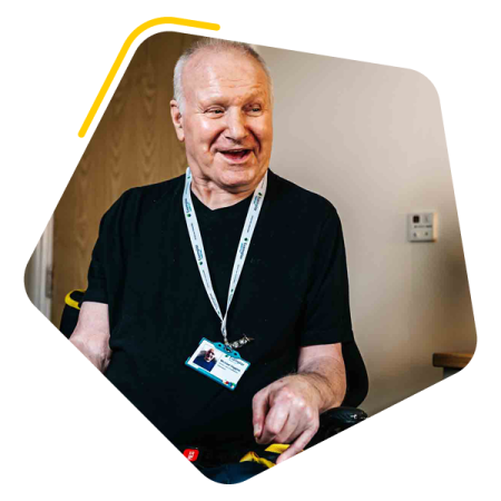Male service user and colleague sat in a lounge