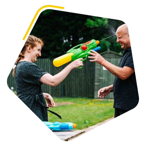 Female with a learning disability playing with a water gun