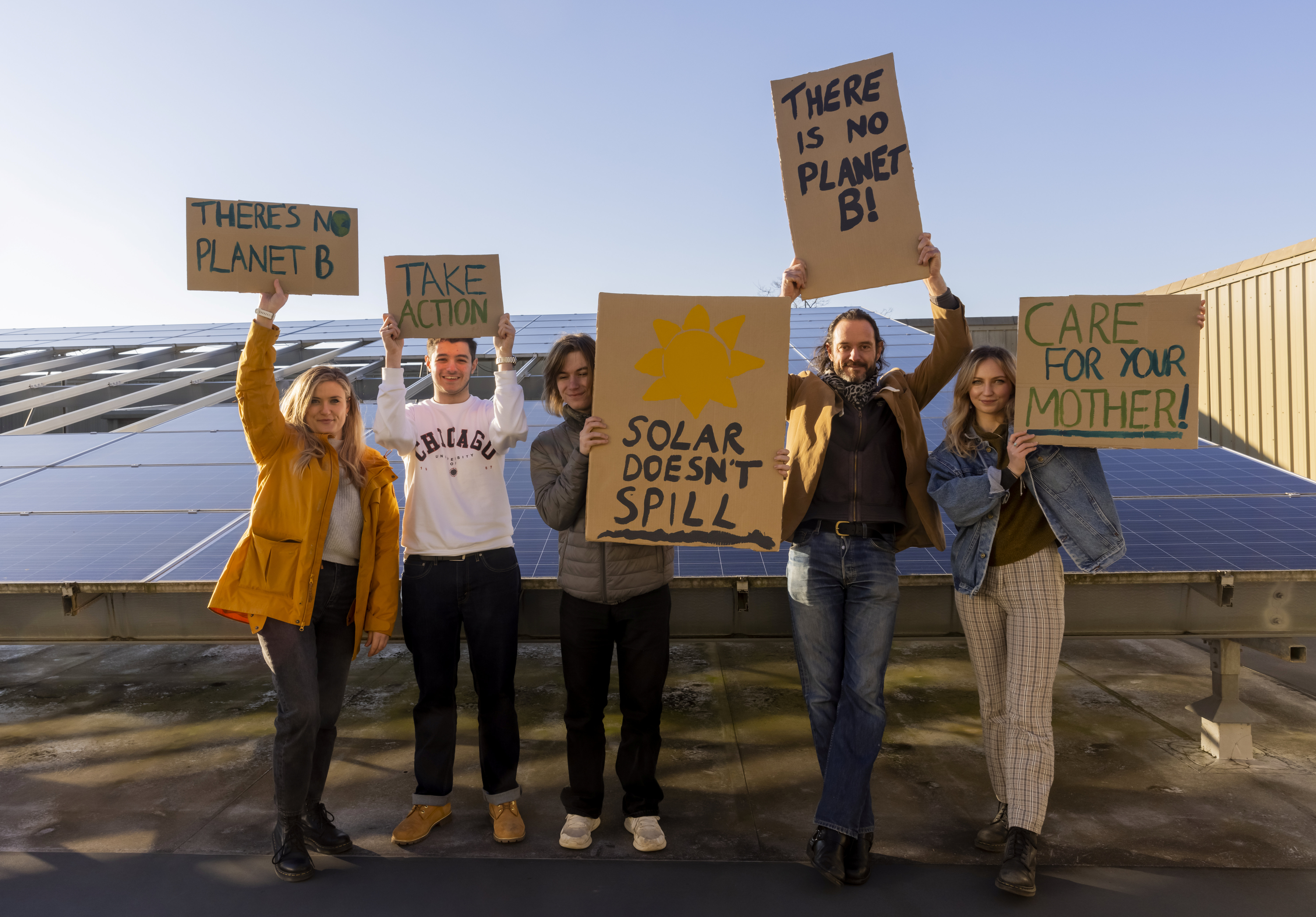 People holding placards in front of solar