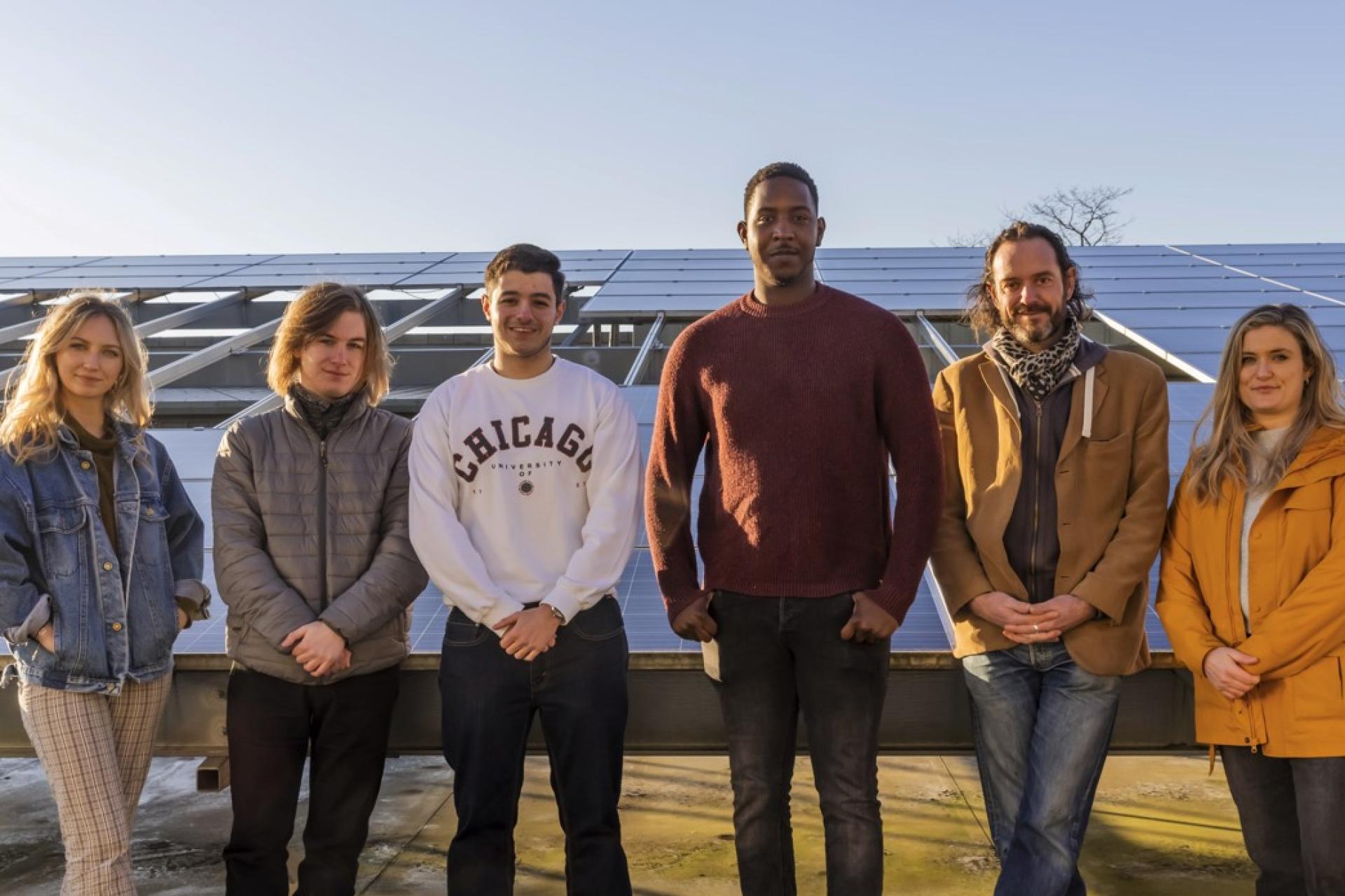 Group of people in front of solar panels 