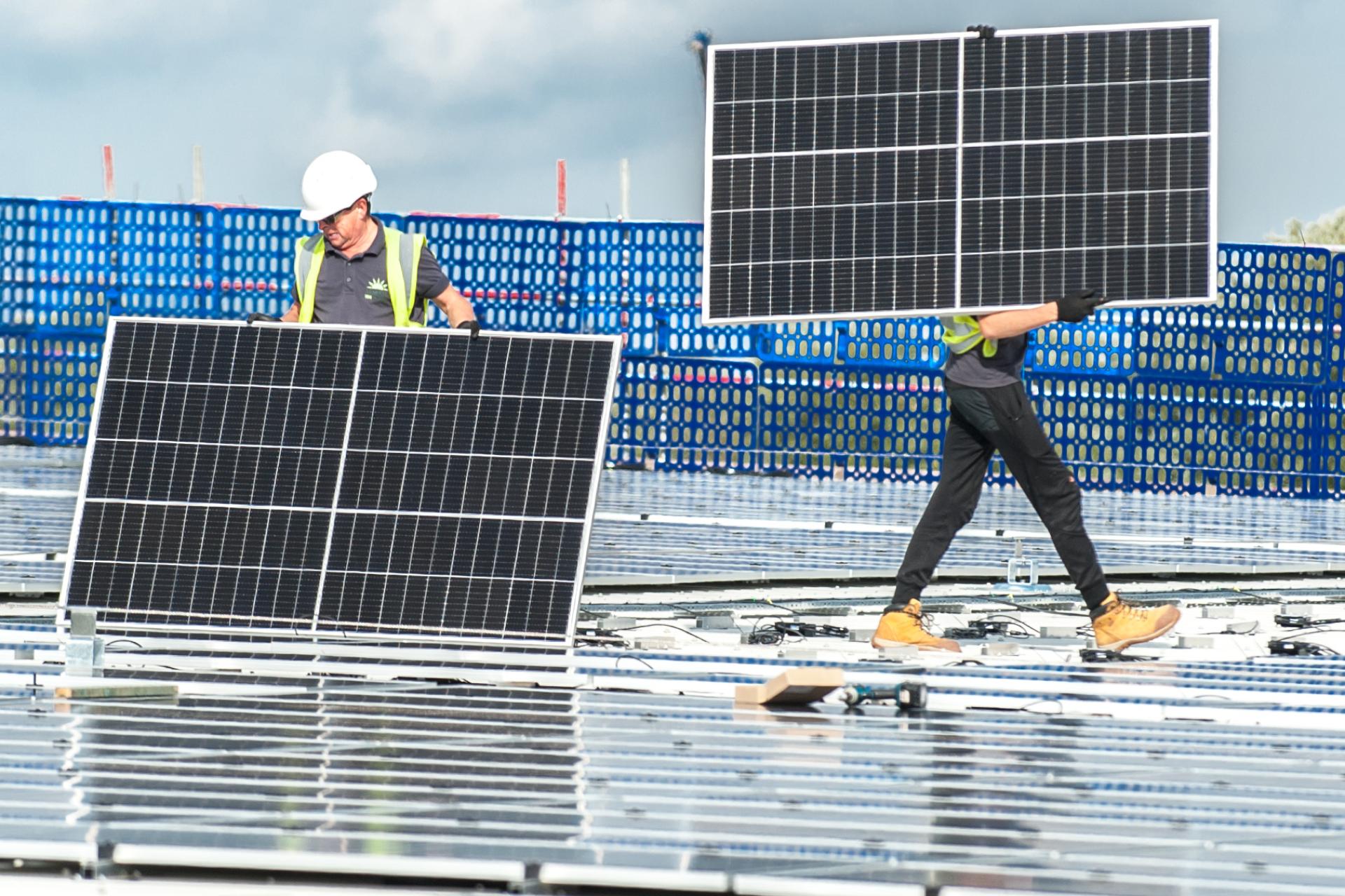 Engineers installing solar panels on a rooftop project.